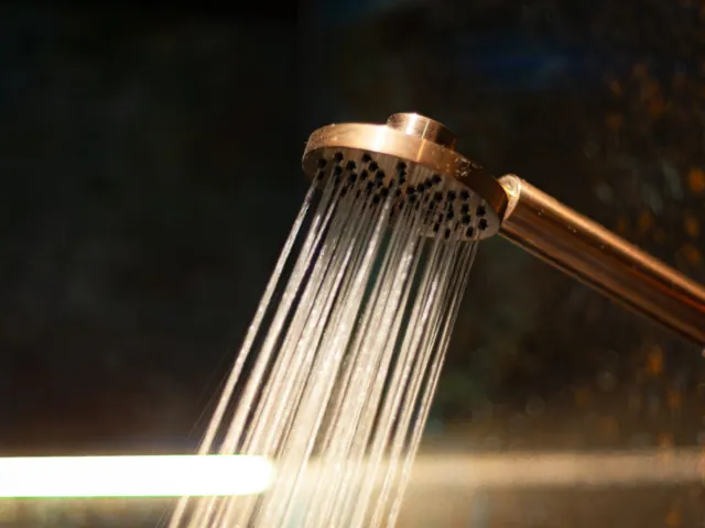 Copper shower handset with water running