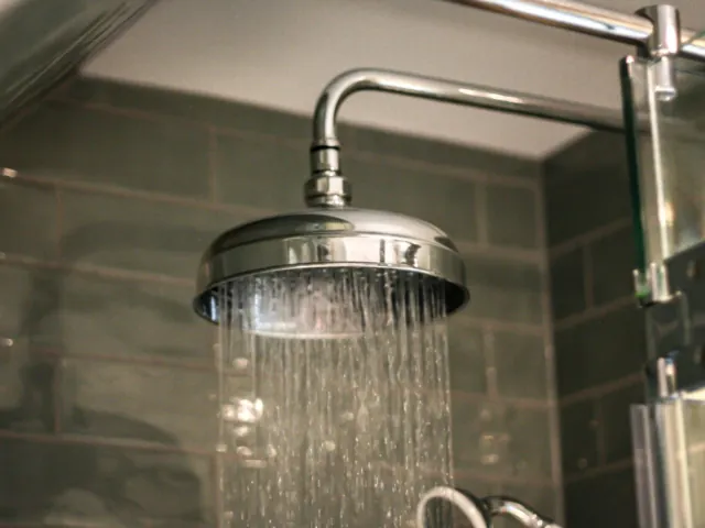 Traditional chrome rain shower head with water running