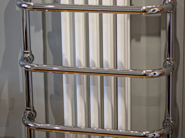 Traditional chrome towel rail in front of a white column radiator