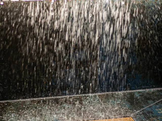 Rain shower falling against dark tiles